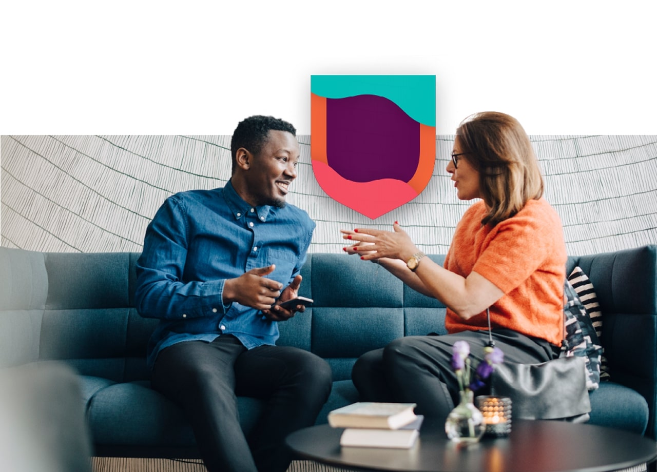 Man and woman talking on a couch.